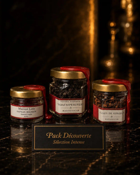 Trio d’épices du Pack Découverte Sélection Intense Maison Loïs — Safran Iranien Negin, Poivre Sauvage Voatsiperifery et Clous de Girofle de Madagascar présentés sur marbre noir dans un décor luxueux.